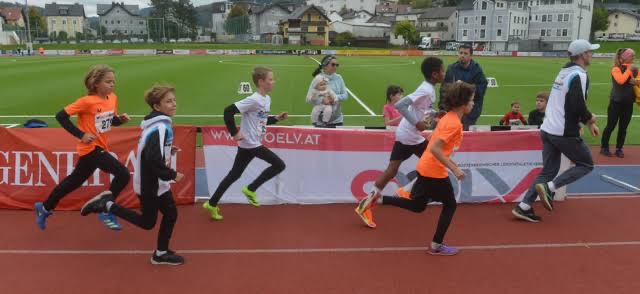 Gruppe von Kindern beim Laufbewerb auf der Rundbahn